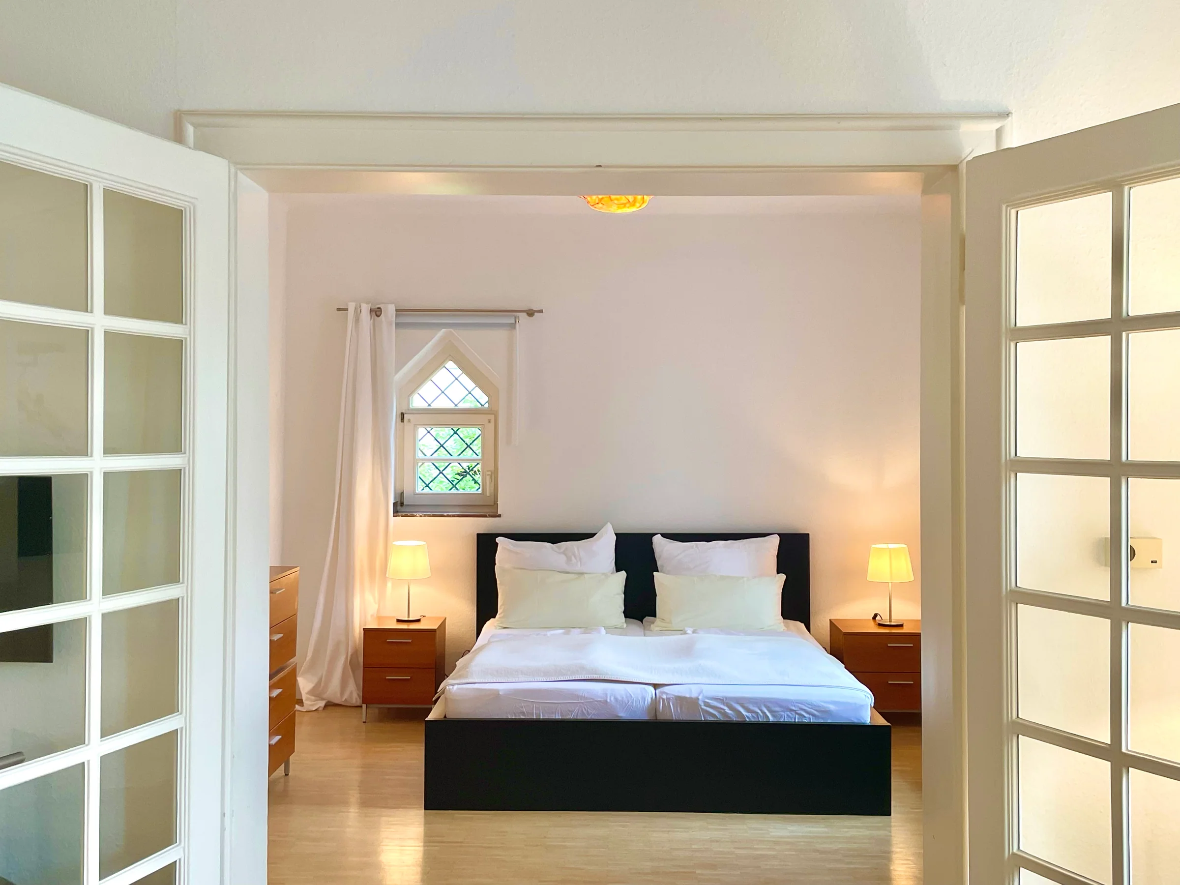 Schlafzimmer mit Doppelbett und Flügeltüren